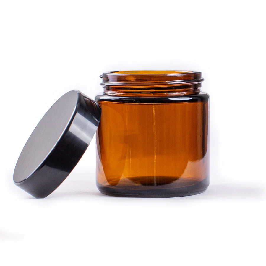Amber glass jar with a black lid on a white background