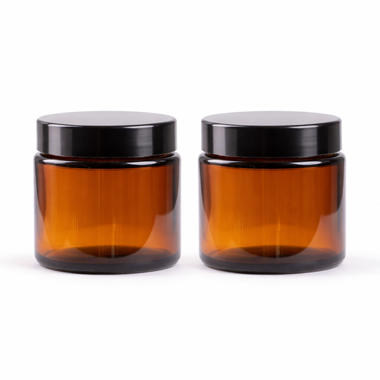 Two amber glass jars with black lids on a white background
