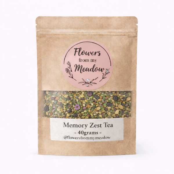 Kraft paper tea bag with 'Flowers from my Meadow' label and tea contents on a white background