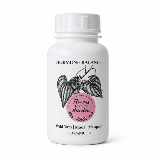 A white plastic supplement bottle with a white ribbed cap, featuring a label for 'Flowers from my Meadow' 'Hormone Balance' capsules. The label includes a black botanical illustration of a yam and a pink circular badge.