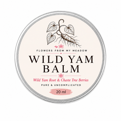 A round metal tin of 'Wild Yam Balm' by the brand 'Flowers From My Meadow'. The label is cream-colored with black text and an illustration of a wild yam root, accented with pink text and a pink paint-stroke detail at the bottom indicating a 20 ml size.