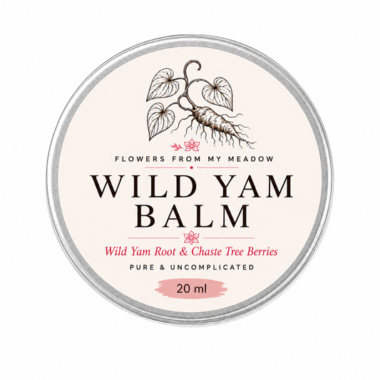 A round metal tin of 'Wild Yam Balm' by the brand 'Flowers From My Meadow'. The label is cream-colored with black text and an illustration of a wild yam root, accented with pink text and a pink paint-stroke detail at the bottom indicating a 20 ml size.