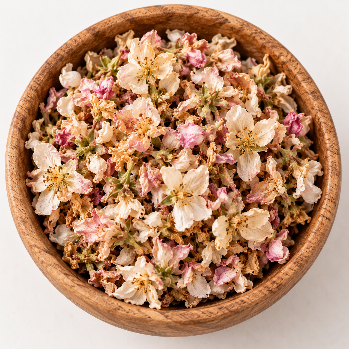 Dried Apple Flowers in a wooden bowl showing the natural cream, blush pink and soft green tones of the blossoms
