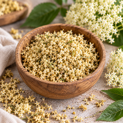 Dried Elderflowers in a wooden bowl showing the natural cream, pale yellow and soft green tones of the blossoms