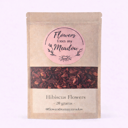 Kraft paper packaging of hibiscus flowers with a pink label on a light purple background