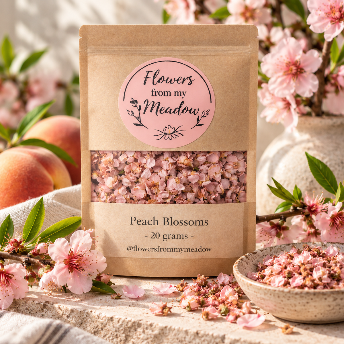 Peach Blossoms 20 g resealable kraft pouch filled with dried pink blossoms, styled with fresh peach flowers, green leaves and ripe peaches