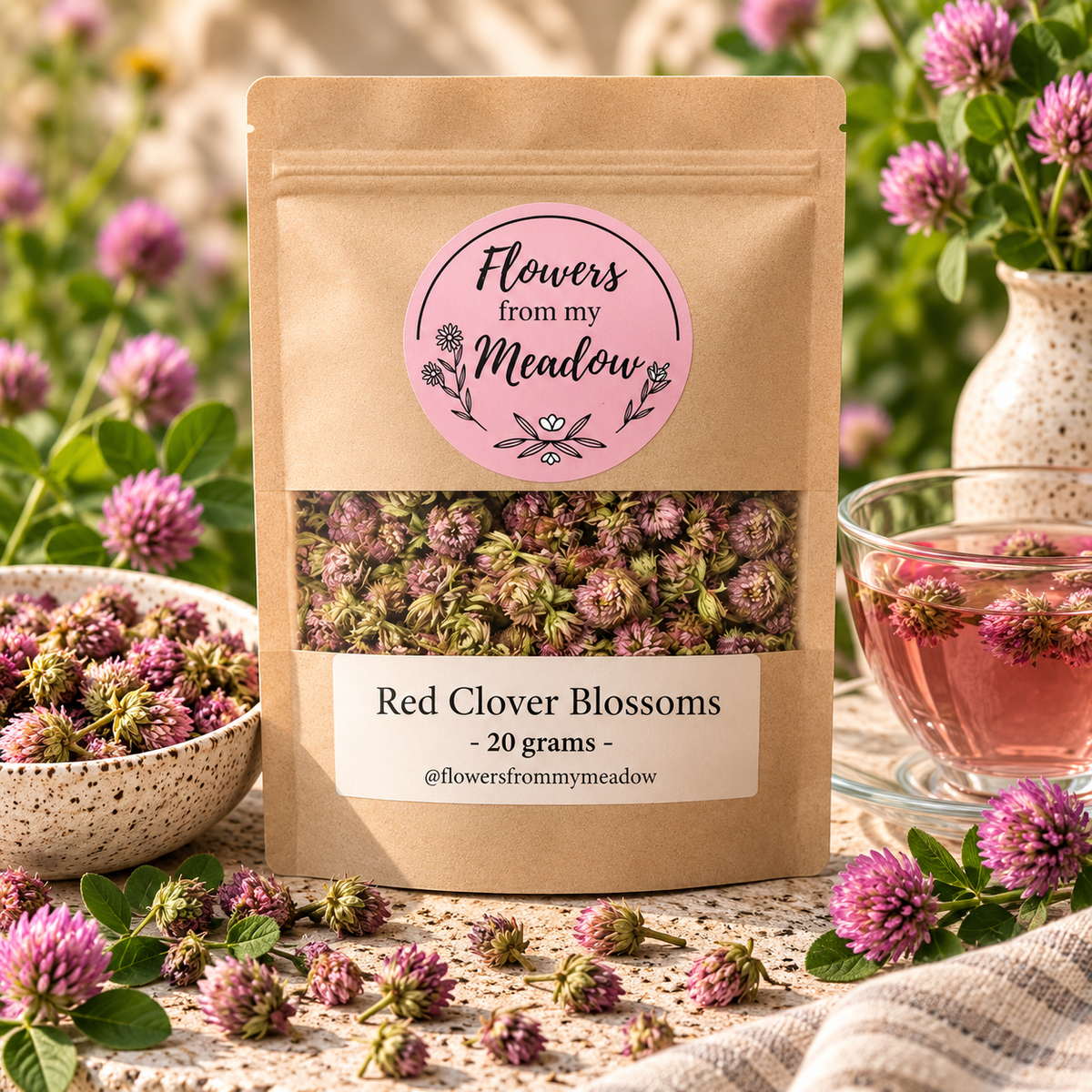 Red Clover Blossoms 20 g resealable kraft pouch filled with dried pink and green clover blossoms, styled with fresh red clover flowers and a rosy botanical infusion