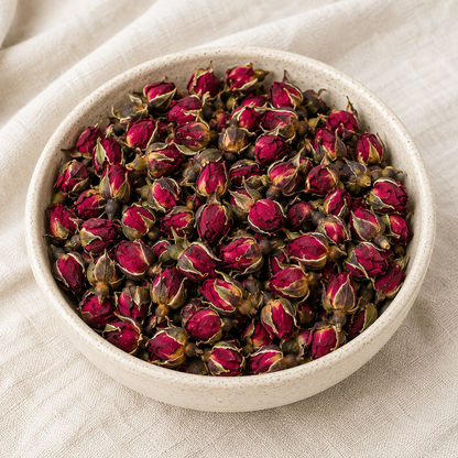 Dried Red Rose Buds in a ceramic bowl showing deep red petals and natural green sepals